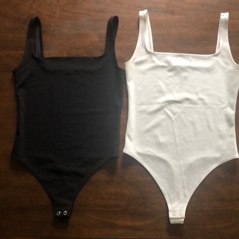 The pair of black and white bodysuits